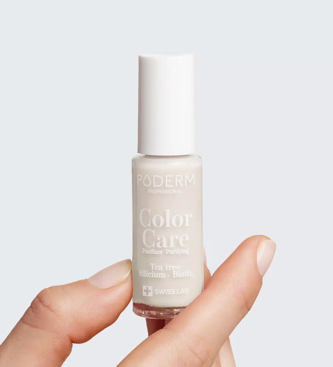 Vernis Nude entre Doigts avec Étiquette PODERM et Ingrédients, Fond Gris Clair
